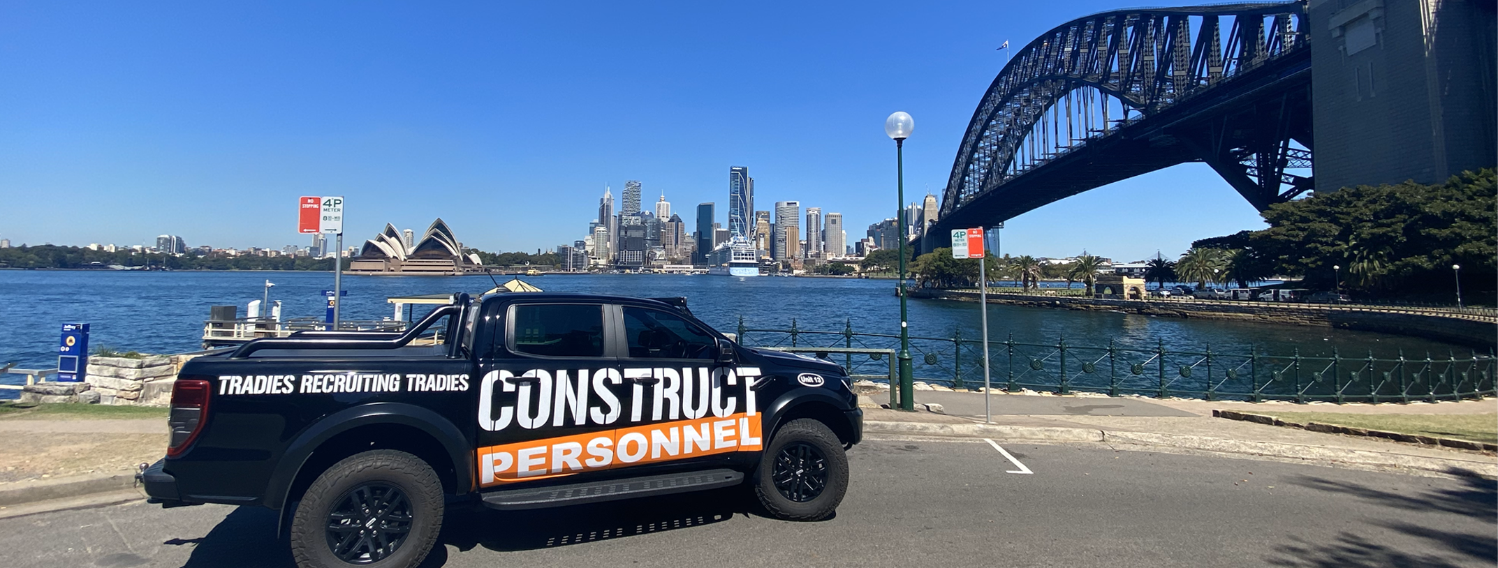 Branded Construct Personnel company vehicle parked in front of the Sydney Harbor Bridge and Opera House.